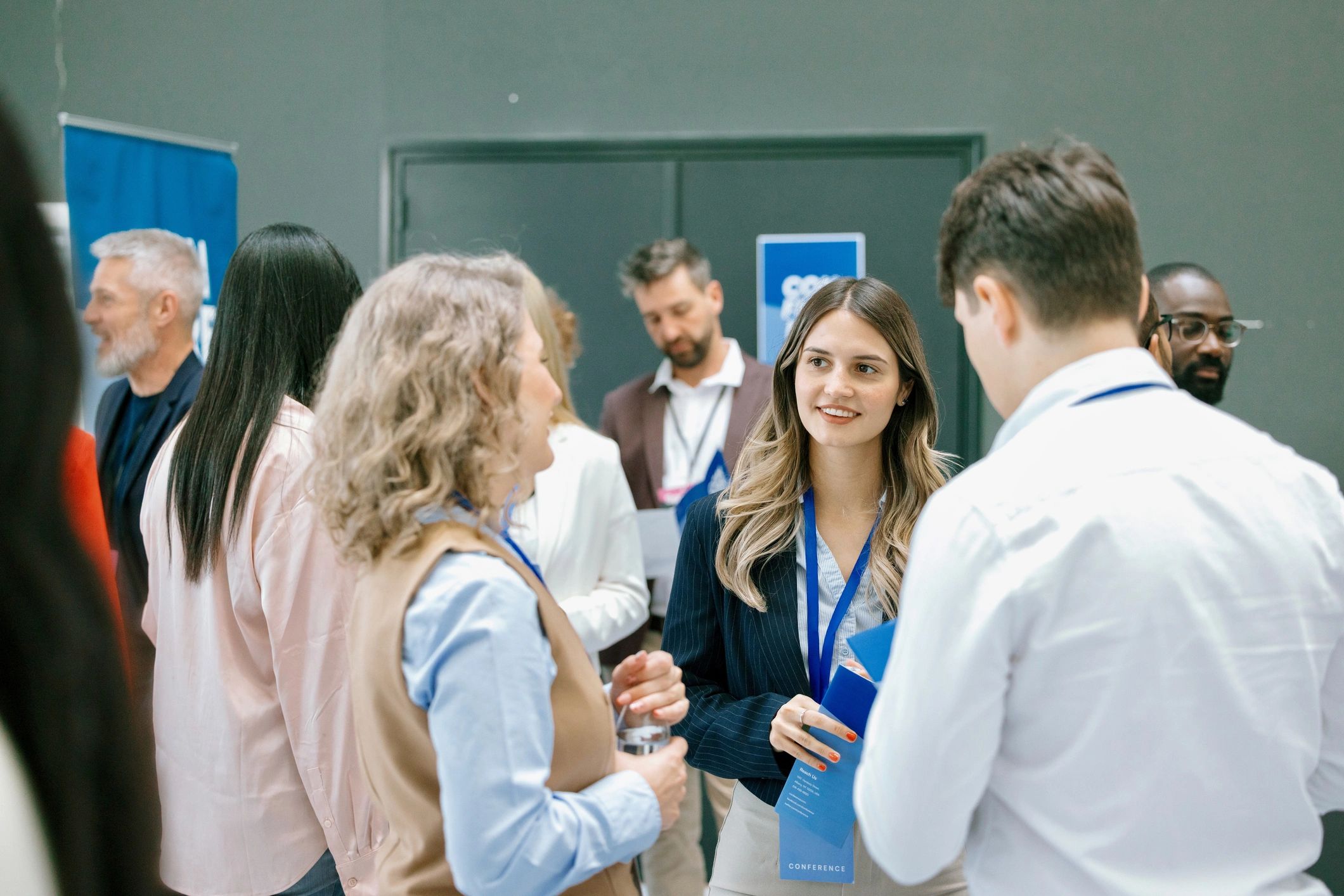 Young entrepreneur speaking with attendees at a networking event
